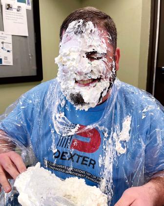 Bryan King grins after taking a pie to the face