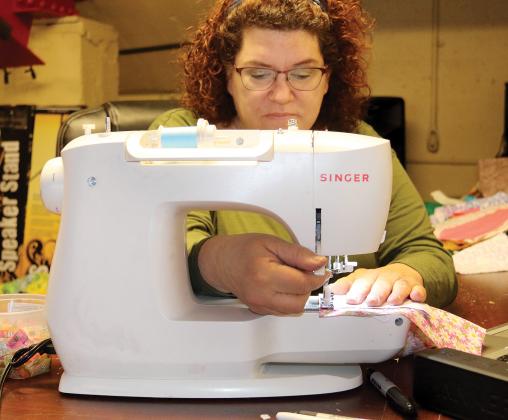Richardson slips a lever on her sewing machine