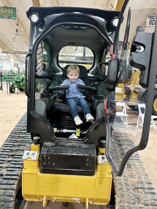 A future farmer plays with the controls on this piece of farm equipment