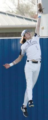 Dacien Ramos leaps at the wall of the Hub Reed Complex while trying to snag a fly ball