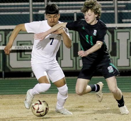 Angel Martinez tries to push past McGuinness player for control of the ball