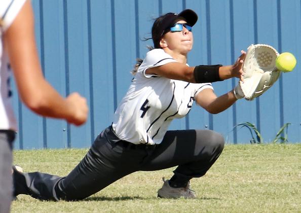 Krystiana Guzman slides down to her knees to try and scoop up a hit