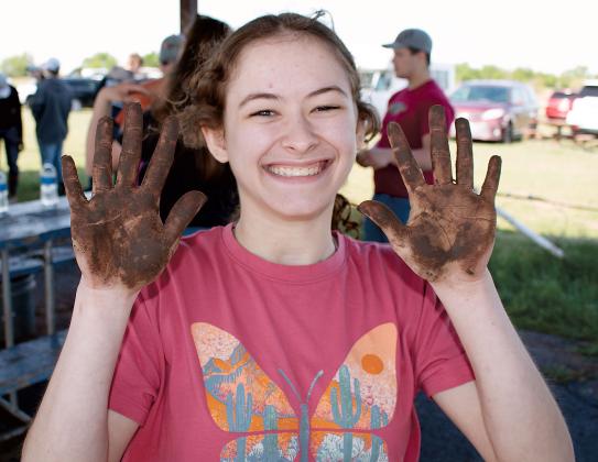Emma Selensky shows off her dirty hands after examining the soil