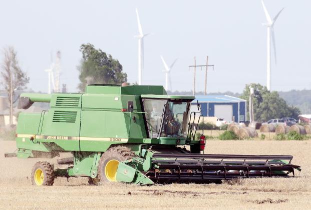 A farmer uses a combine to cut wheat in a field south of Calumet