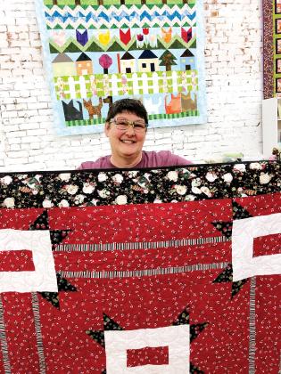 MaCrae Putnam shows off some of the quilts to be displayed