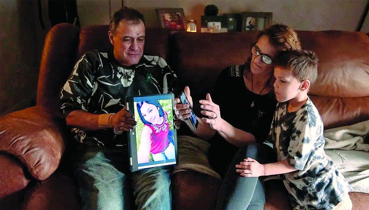 Freddy Corona and Shawna Normali look at photos of their daughter, Lena Corona, with their son, Josh Corona