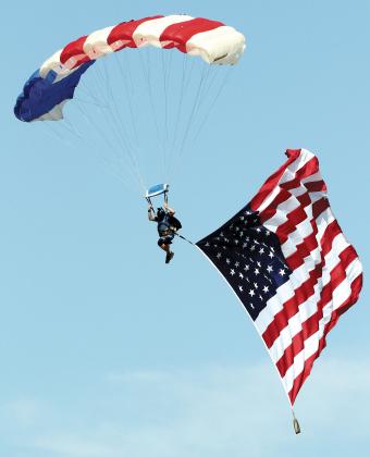 A member of Skydive Airtight glides with the American flag in tow