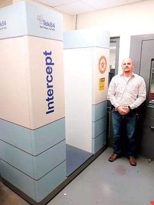 Austin Moore stands beside the new full-body scanner