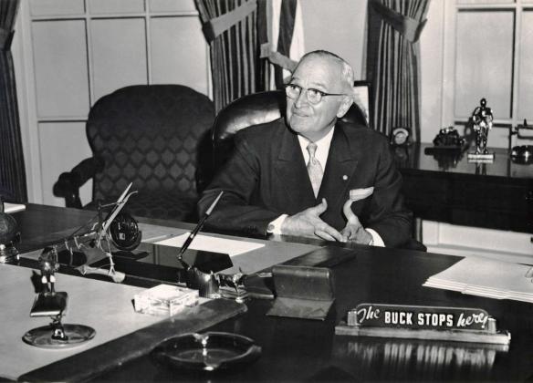 Harry S. Truman is shown here at his White House desk with the famous desk plate