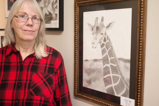 Sue Smith stands next to her original art