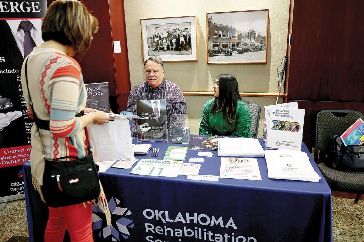 A woman talks with staff of the Oklahoma Department of Rehabilitation Services