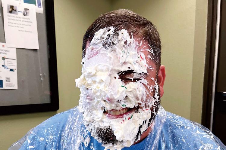 Bryan King grins after taking a pie to the face