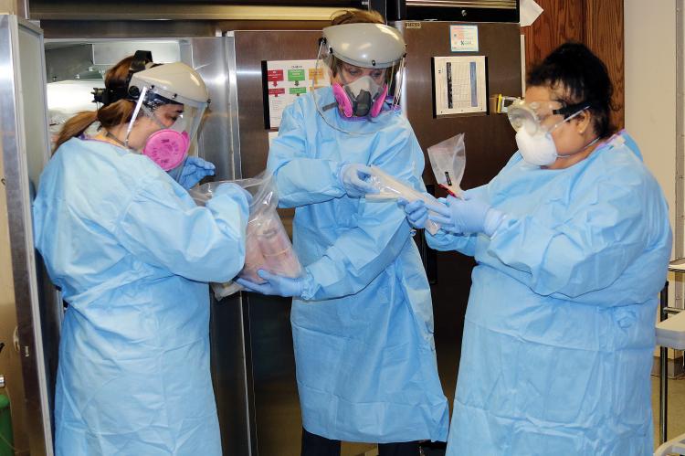 Canadian County Health Department workers wear full personal protection equipment