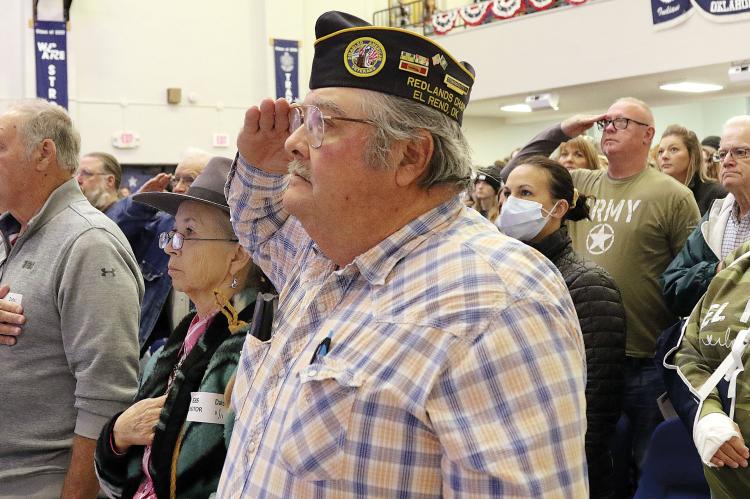 Charles Rukes (center) joins other veterans in saluting