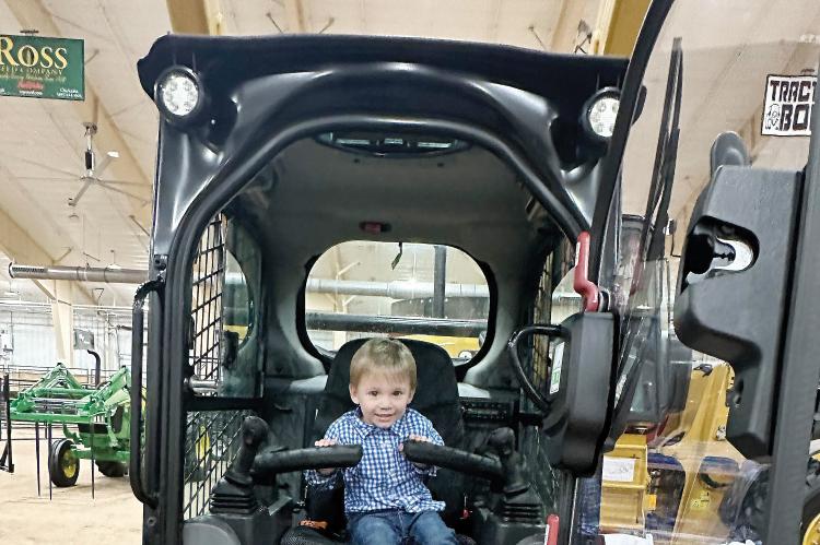 A future farmer plays with the controls on this piece of farm equipment