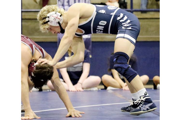 El Reno wrestler Dailey Jennings, above, pushes down the head of his Perry opponent while setting up a takedown move. 
