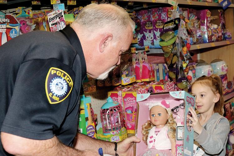 Sam Webster checks for the price of a doll picked out by his shopping buddy Journey Cochran