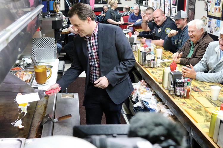 Todd Piro cracks an egg during a live shot at Sid’s Diner