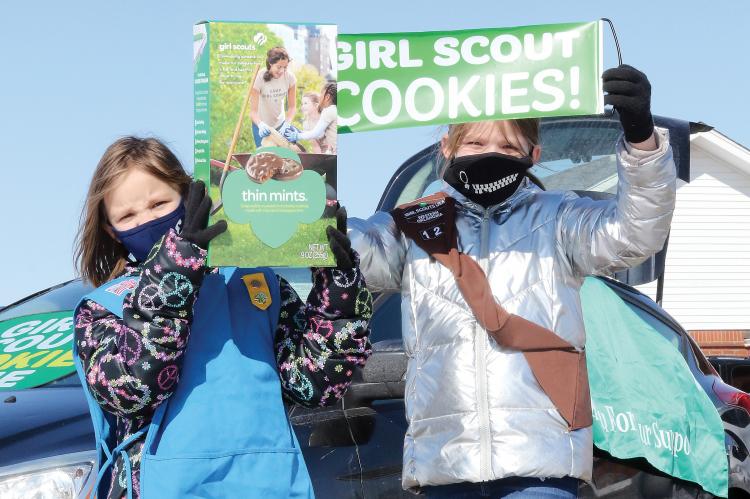Makayla and Chloe Owen hold up signs to attract passing motorists