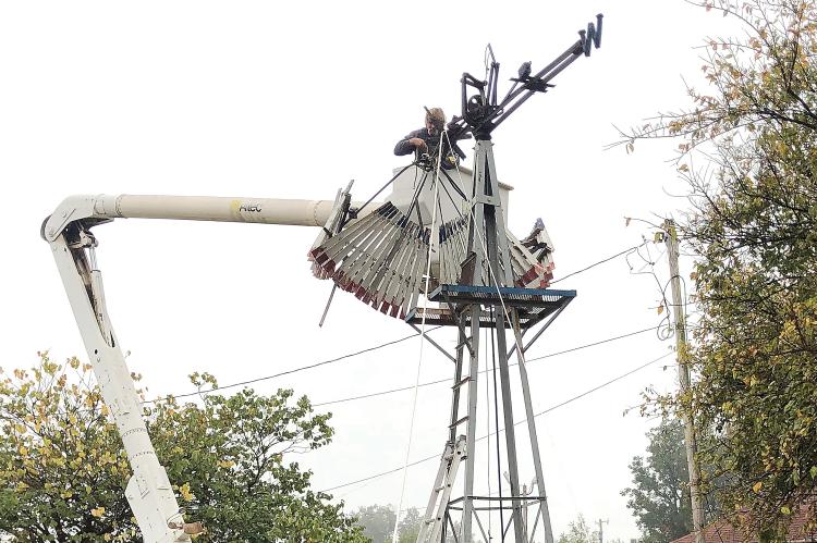 Volunteers worked Friday to take down the historic windmill