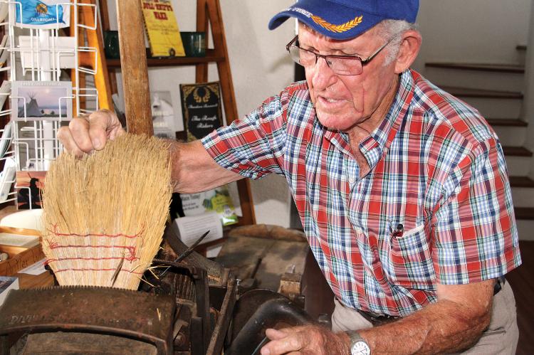 J.D. Miller shows how to adjust his broom-making machine