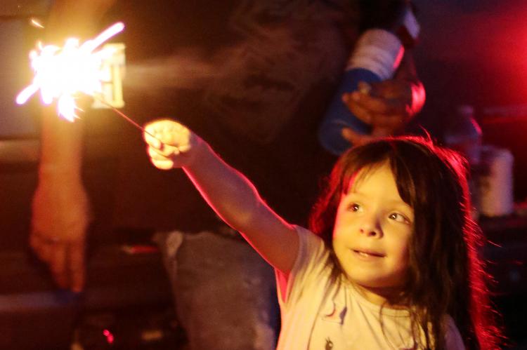 Isabelle Arias stares at a sparkler