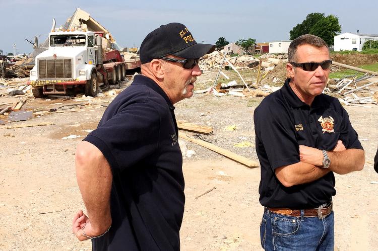 Ken Brown, left, and Kent Lagaly discuss tornado damage