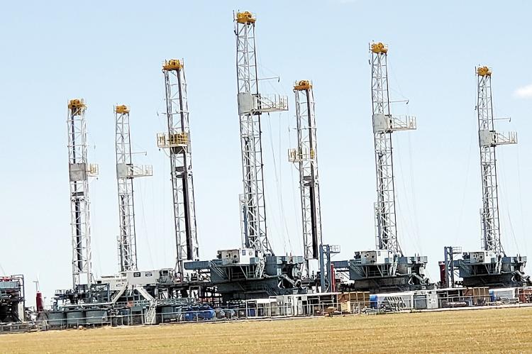Oil derricks sit in a field northeast of Calumet