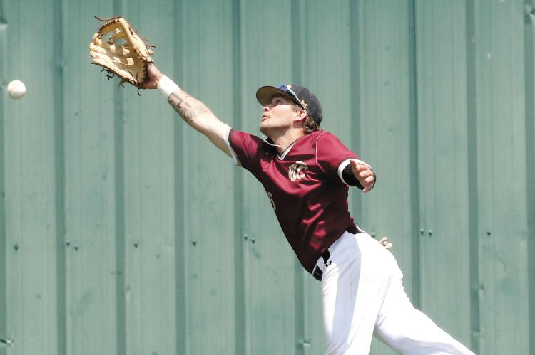Dustin Whitmire leaps into the air as he tries to snag a fly ball