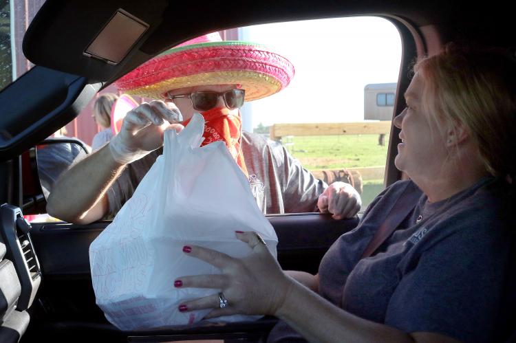 Craig McVay hands a sack of taco dinners to Annie Pearson