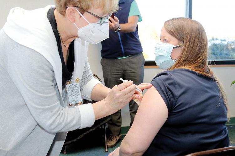 An employee with SSM Health St. Anthony’s gets her first round of the Pfizer vaccine