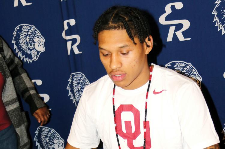 Dorian Plumley reads over the letter of intent he signed with OU