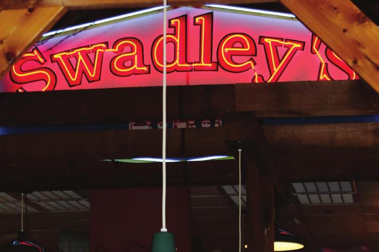 Swadley’s Bar-B-Q waitress Jasmine Bumgamer wipes down tables