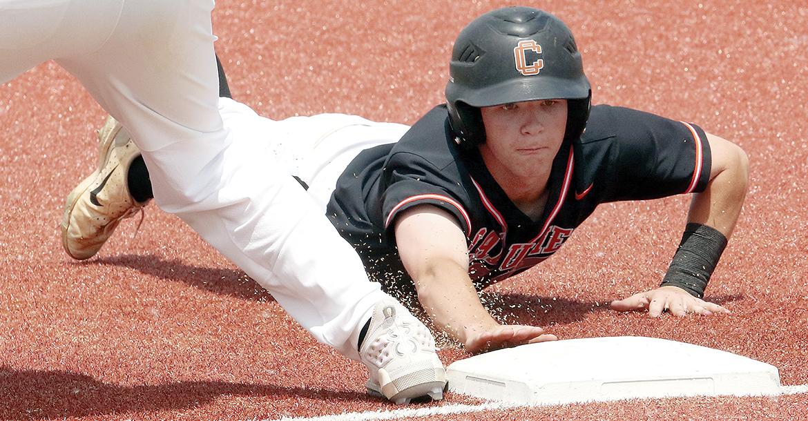 Kingston Arnold dives back into first base ahead of a pickoff throw_slideshow